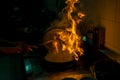 Chef cooking and doing flambe on food in kitchen Royalty Free Stock Photo
