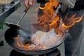 Chef cooking with fire in frying pan Royalty Free Stock Photo