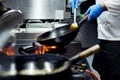 Chef cooking with flame in a frying pan on a kitchen stove Royalty Free Stock Photo