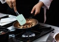 Chef cooking with flame in a frying pan on a kitchen stove Royalty Free Stock Photo