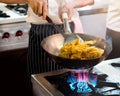 Chef cooking with flame in a frying pan on a kitchen stove Royalty Free Stock Photo