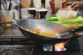 Chef cooking with flame in a frying pan on  kitchen stove, Chef in restaurant kitchen at stove with pan Royalty Free Stock Photo