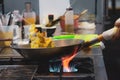 Chef cooking with flame in a frying pan on a kitchen stove, Chef Royalty Free Stock Photo