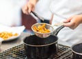 Chef is cooking french fries in the kitchen, Chef cooking fried potato in pan Royalty Free Stock Photo