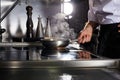 Chef cooking in frying pan on kitchen stove, cropped Royalty Free Stock Photo