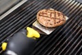 Chef cooking a hamburger patty on a grill