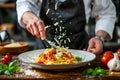 Chef cooking Italian pasta and adding parmesan cheese to the dish Royalty Free Stock Photo