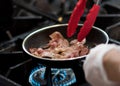 Chef cooking in the kitchen, fresh fried bacon in a pan