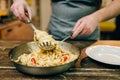 Chef cooking pasta, pan on wooden kitchen table Royalty Free Stock Photo