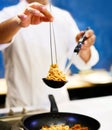 Chef cooking pasta, Chef serves spaghetti carbonara on the plate in the kitchen Royalty Free Stock Photo