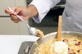 Chef cooking risotto with dried tomato