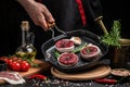 Chef cooking steak on grill pan with rosemary and spices. Beef medallions wrapped in bacon. Culinary, cooking concept Royalty Free Stock Photo