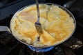 The chef is cooking and stirring the omelette. Unrecognizable hands taking out fresh omelet from frying pan. Cooking Royalty Free Stock Photo