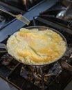 The chef is cooking and stirring the omelette. Unrecognizable hands taking out fresh omelet from frying pan. Cooking Royalty Free Stock Photo