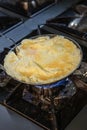 The chef is cooking and stirring the omelette. Unrecognizable hands taking out fresh omelet from frying pan. Cooking Royalty Free Stock Photo