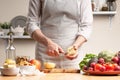 The chef cooks, cuts an apple, in the process of a vegetarian salad with the hand of the chef in the home kitchen. Light Royalty Free Stock Photo