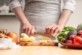 The chef cooks, cuts an apple, in the process of a vegetarian salad with the hand of the chef in the home kitchen. Light Royalty Free Stock Photo