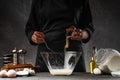 The chef cooks the dough, pouring out the shiver. Freeze in motion. Against the background of ingredients. Cooking baking