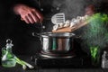 The chef cooks dumplings in a saucepan in the restaurant kitchen. Close-up of the hands of the cook during work Royalty Free Stock Photo