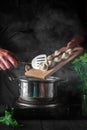 The chef cooks dumplings in a saucepan in the restaurant kitchen. Close-up of the hands of the cook during work Royalty Free Stock Photo