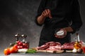 Chef cooks fresh pork or beef ribs. Against the background of vegetables. Flying, freezing motion. With space for advertising Royalty Free Stock Photo