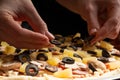 Chef cooks pizza, puts olives on the background with ingredients. Recipe book, menu, home cooking, pizzeria. Macro, close-up Royalty Free Stock Photo