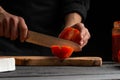 Chef cooks pizza, slices fresh tomatoes, on the background with ingredients. Recipe book, menu, home cooking. close-up Royalty Free Stock Photo