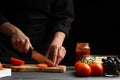 Chef cooks pizza, slices fresh tomatoes, on the background with ingredients. Recipe book, menu, home cooking. close-up Royalty Free Stock Photo