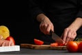 Chef cooks pizza, slices fresh tomatoes, on the background with ingredients. Recipe book, menu, home cooking. close-up Royalty Free Stock Photo