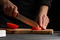 Chef cooks pizza, slices fresh tomatoes, on the background with ingredients. Recipe book, menu, home cooking. close-up Royalty Free Stock Photo