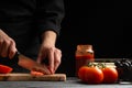 Chef cooks pizza, slices fresh tomatoes, on the background with ingredients. Recipe book, menu, home cooking. Horizontal frame Royalty Free Stock Photo