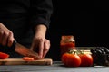 Chef cooks pizza, slices fresh tomatoes, on the background with ingredients. Recipe book, menu, home cooking. Horizontal frame Royalty Free Stock Photo