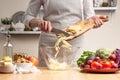 Chef cooks, slices an apple, stir, in the process of a vegetarian salad with the hand of the chef in the home kitchen Light Royalty Free Stock Photo