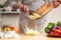 Chef cooks, slices an apple, stir, in the process of a vegetarian salad with the hand of the chef in the home kitchen Light Royalty Free Stock Photo