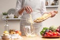 Chef cooks, slices an apple, stir, in the process of a vegetarian salad with the hand of the chef in the home kitchen Light Royalty Free Stock Photo