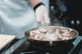 The chef cooks the small octopus on a metal frying pan Royalty Free Stock Photo