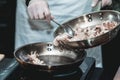 The chef cooks the small octopus on a metal frying pan Royalty Free Stock Photo