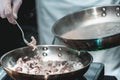 The chef cooks the small octopus on a metal frying pan Royalty Free Stock Photo