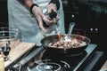 The chef cooks the small octopus on a metal frying pan Royalty Free Stock Photo