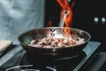 The chef cooks the small octopus on a metal frying pan Royalty Free Stock Photo