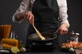 Chef cooks vegetables with shrimps in a pan, in butter, heating a frying pan. Ingredients and vegetables, on a gray background