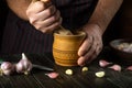The chef crushes garlic on the kitchen table before adding it to the food. Close-up of a cook hand crushing garlic in a wooden Royalty Free Stock Photo