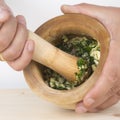 Chef crushing garlic and parsley with mortar and pestle in the k Royalty Free Stock Photo