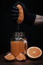 Chef crushing orange in glass