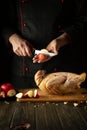 The chef cuts an apple before adding it to a raw duck for roasting in the oven. Cooking a national dish or Peking duck in the Royalty Free Stock Photo