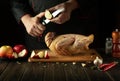 The chef cuts an apple before adding it to a raw duck for roasting in the oven. Cooking a national dish or Peking duck in the Royalty Free Stock Photo