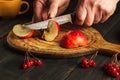 Chef cuts apple on a cutting board with a knife to make compote or fruit juice. Apple diet for a set of vitamins. Working Royalty Free Stock Photo