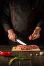 The chef cuts beef raw meat on a cutting board before barbecue. Asian cuisine. Preparing a delicious meal in the kitchen Royalty Free Stock Photo