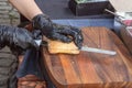 Chef cuts a bun with a knife to make a burger or sandwich.