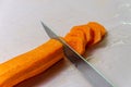 The chef cuts a carrot with a knife